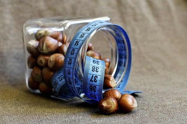 een potje noten verpakt in een maatje van een kleermaker