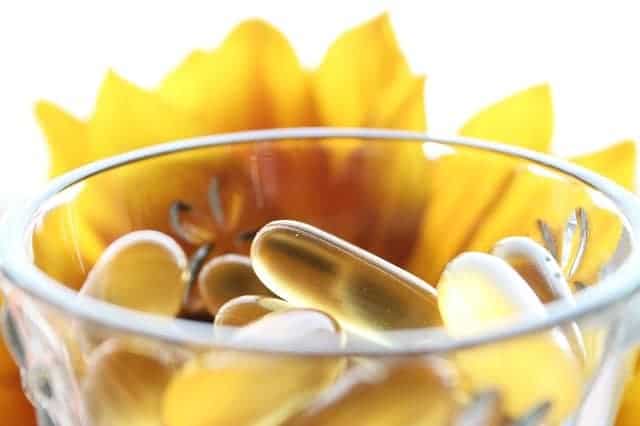 tabletten in een glas, gele bloem op de achtergrond