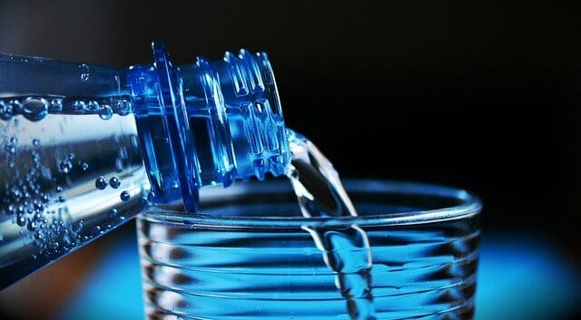  Water uit een fles in een glas gegoten