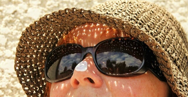  het gezicht van een vrouw met een zonnebril en een hoed