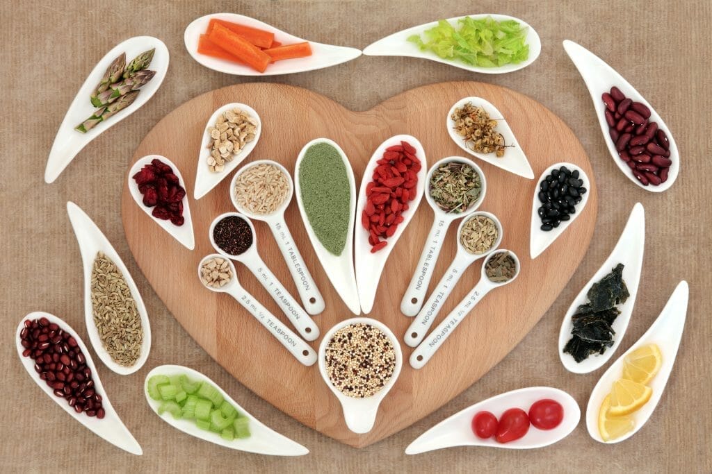  Kruiden en andere gezonde producten liggen op een hartvormige snijplank