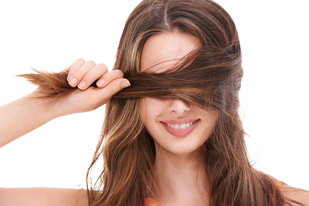 een vrouw houdt haar dikke, sterke haar in haar hand